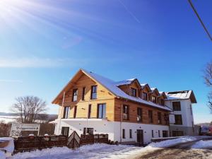 a large wooden building with snow on the ground at Landhotel Berggaststätte Bickenriede in Anrode