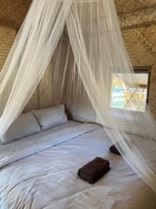 a bed in a tent with mosquito netting at Mook Mellow Hill Bungalows in Ko Mook