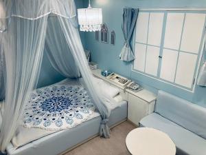 a bedroom with a bed and a table and a window at ホテル フローレス in Tsubame