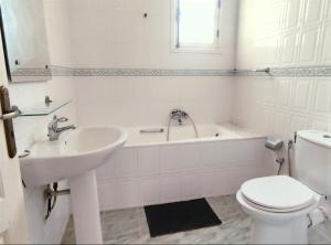a bathroom with a sink and a toilet and a tub at Sunshine Villa in Gabès +3 photos