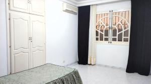 a room with a bed and a door and a window at Sunshine Villa in Gabès