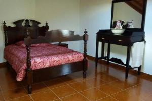 a bedroom with a bed and a mirror and a table at Ribeirinha House in Porto Formoso