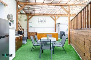 a patio with a table and chairs on grass at וילה לה מונטנייה in Dāliyat el Karmil