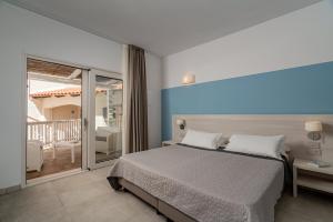 a bedroom with a bed and a balcony at Club Esse Cala Bitta in Baja Sardinia +65 photos