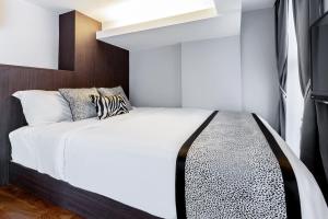 a bedroom with a white bed with black and white pillows at Heritage Collection on Seah - Mobile App Check-In in Singapore