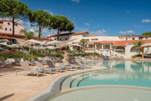 a swimming pool with lounge chairs and a resort at Club Esse Cala Bitta in Baja Sardinia