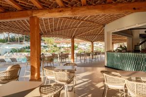 an outdoor restaurant with tables and chairs and tablesktop at Club Esse Cala Bitta in Baja Sardinia