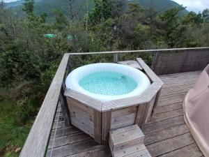 a hot tub sitting on a wooden deck at Bulle en bois sous les étoiles in Champfromier