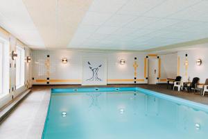 a large swimming pool in a room at De Stobbe hotel & suites in Ruinen