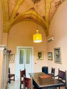a dining room with a table and chairs and a ceiling at Dongiovanni Suite in Lecce