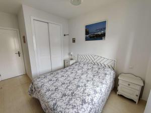 a white bedroom with a bed and a night stand at Casa Mila in El Verger