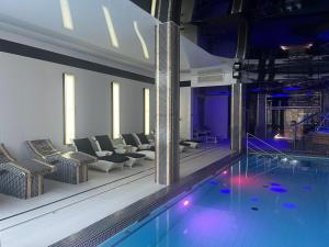 a swimming pool with couches and chairs and a swimming pool at Hotel Business Faltom Gdynia in Gdynia