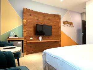 a hotel room with a bed and a tv at Wind Sea Hill Inn in Hengchun South Gate