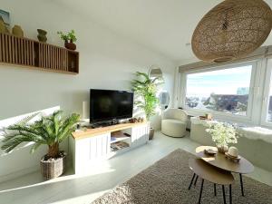 a living room with a tv and a couch at BEACH apartment met directe toegang tot het STRAND ! in Knokke-Heist
