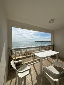 a balcony with a table and chairs and the ocean at Marco Polo in Les Sables-d'Olonne