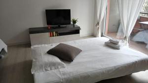 a white bed in a room with a tv at MilanoValery3 in Milan +22 photos