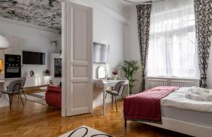 a bedroom with a bed and a desk and a window at NEBarrabona in Győr