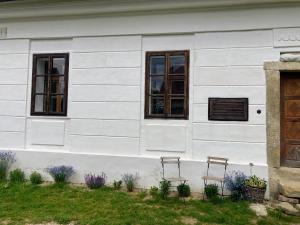 two chairs sitting outside of a white house at Klobucká manufaktura in Valašské Klobouky +19 photos