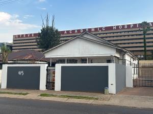 a building with two garage doors in front of a hospital at Entire rental unit in Pretoria