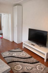 a living room with a flat screen tv on a white table at Zimmer & Apartments Wolfsberg C2 in Wolfsberg