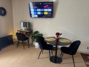 a dining room with a table and chairs and a tv at Belle Vue de St Gervais in Saint-Gervais-les-Bains