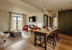 a living room with a wooden table and chairs at Dumbarnie East Cottage in Kirkton of Largo