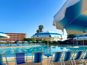 a group of chairs and umbrellas next to a swimming pool at Fruit Village Capo Rizzuto S Antonio in Capo Rizzuto