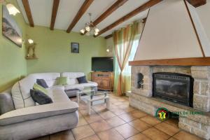 a living room with a couch and a fireplace at Le clos du bas in Noyal-Muzillac