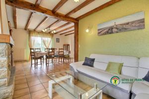 a living room with a white couch and a table at Le clos du bas in Noyal-Muzillac