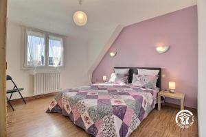 a bedroom with a bed with a purple wall at Le clos du bas in Noyal-Muzillac
