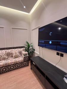 a living room with a couch and a large flat screen tv at A big house -Isteraha- in Malham