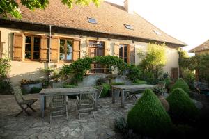 a garden with tables and chairs in front of a building at Les hauts des Soussilanges in Céron