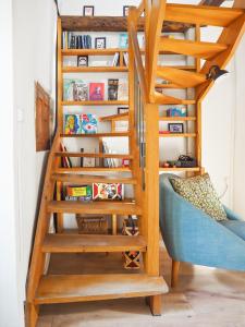 a staircase in a living room with a blue couch at Chez Philomène in Aubusson