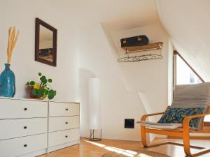 a living room with a chair and a dresser at Chez Philomène in Aubusson