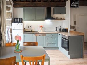 a kitchen with blue cabinets and a table with chairs at Chez Philomène in Aubusson