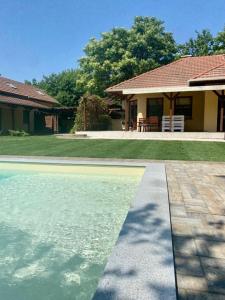 a house with a swimming pool in front of a house at Charlie porta in Abádszalók