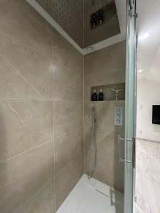 a shower with a glass door in a bathroom at Appartement cosy 2 chambres in Jougne