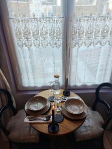 a table with plates and candles and a window at Villa Seven Petit Studio coin kitchenette in Dunkerque