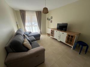 a living room with a couch and a television at Apartamento Senda in Comillas