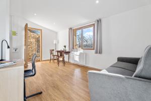 a living room with a couch and a table at Le Cocon de la Combe - Maisonnette pour 4p in Coursegoules +9 photos