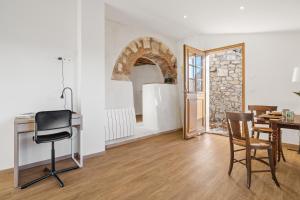 a room with a desk and a table and chairs at Le Cocon de la Combe - Maisonnette pour 4p in Coursegoules