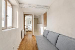 a living room with a couch and a window at Le Cocon de la Combe - Maisonnette pour 4p in Coursegoules