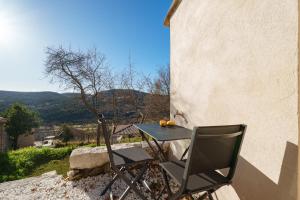 a table and chairs sitting on the side of a building at Le Cocon de la Combe - Maisonnette pour 4p in Coursegoules