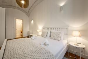 a bedroom with a large white bed with two lamps at Deluxe Apartment Talia by Irundo in Zagreb +4 photos