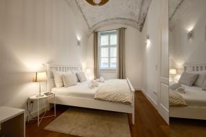 a white bedroom with a bed and a window at Deluxe Apartment Talia by Irundo in Zagreb