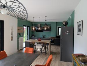 a kitchen and dining room with a table and a refrigerator at Fleurs in Bassussarry