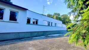 a white building with trees in front of it at Noclegi Witoszyn - Akacjowa 2 in Witoszyn Dolny