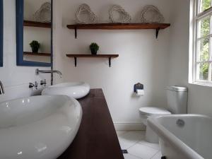 a bathroom with two sinks and a tub and a toilet at Coach House Bed and Breakfast in Greytown +3 photos