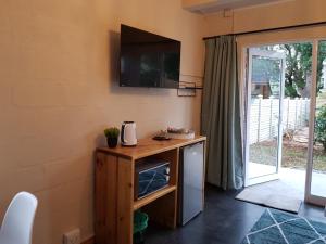a kitchen with a microwave and a tv on the wall at Coach House Bed and Breakfast in Greytown