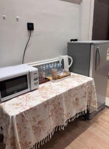 a microwave sitting on a table next to a refrigerator at A big house -Isteraha- in Malham